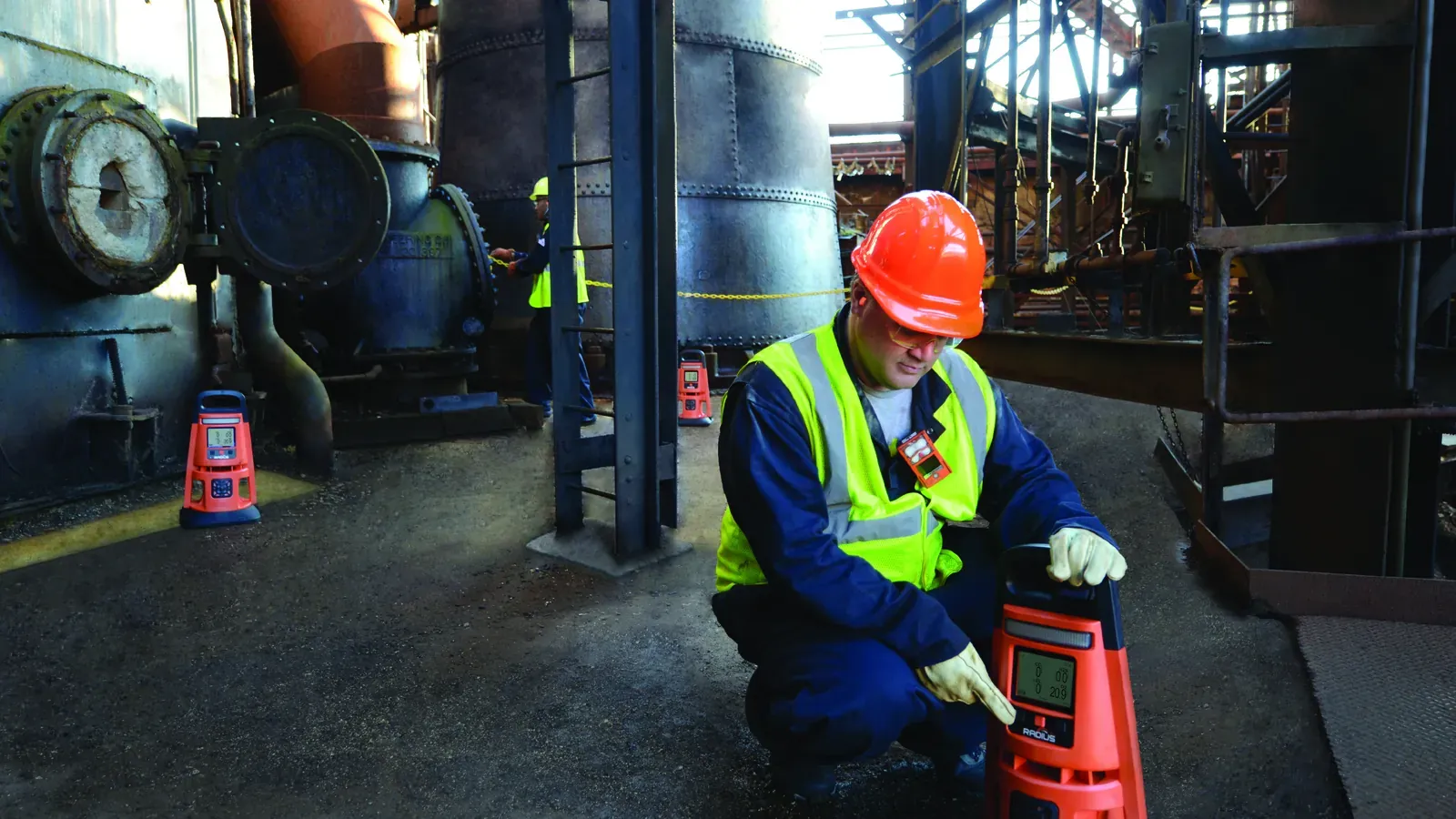 Industrial Scientific field service technician monitoring gas levels with a Radius BZ1 area monitor in an active treatment plant